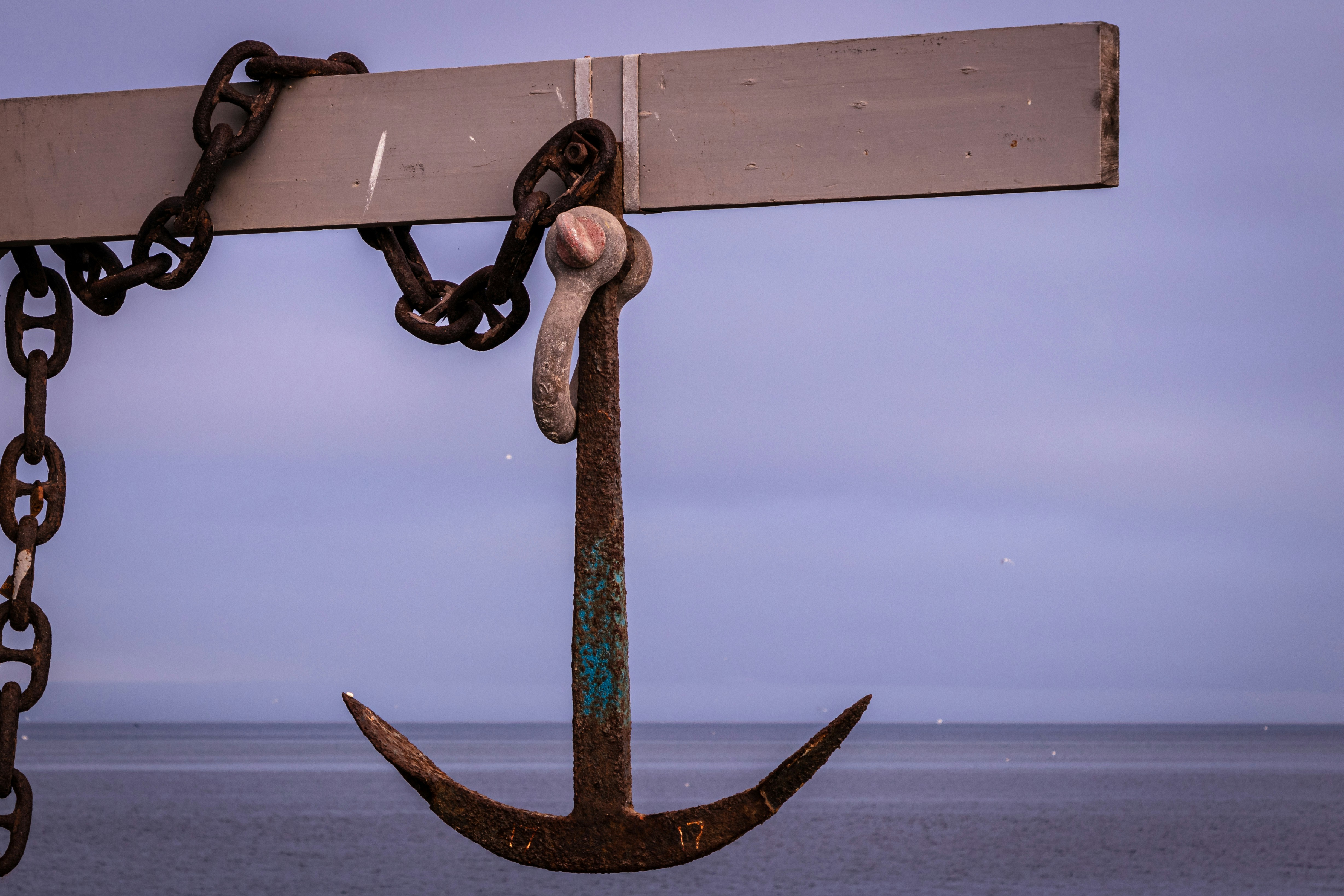 A rusty anchor in front of the ocean