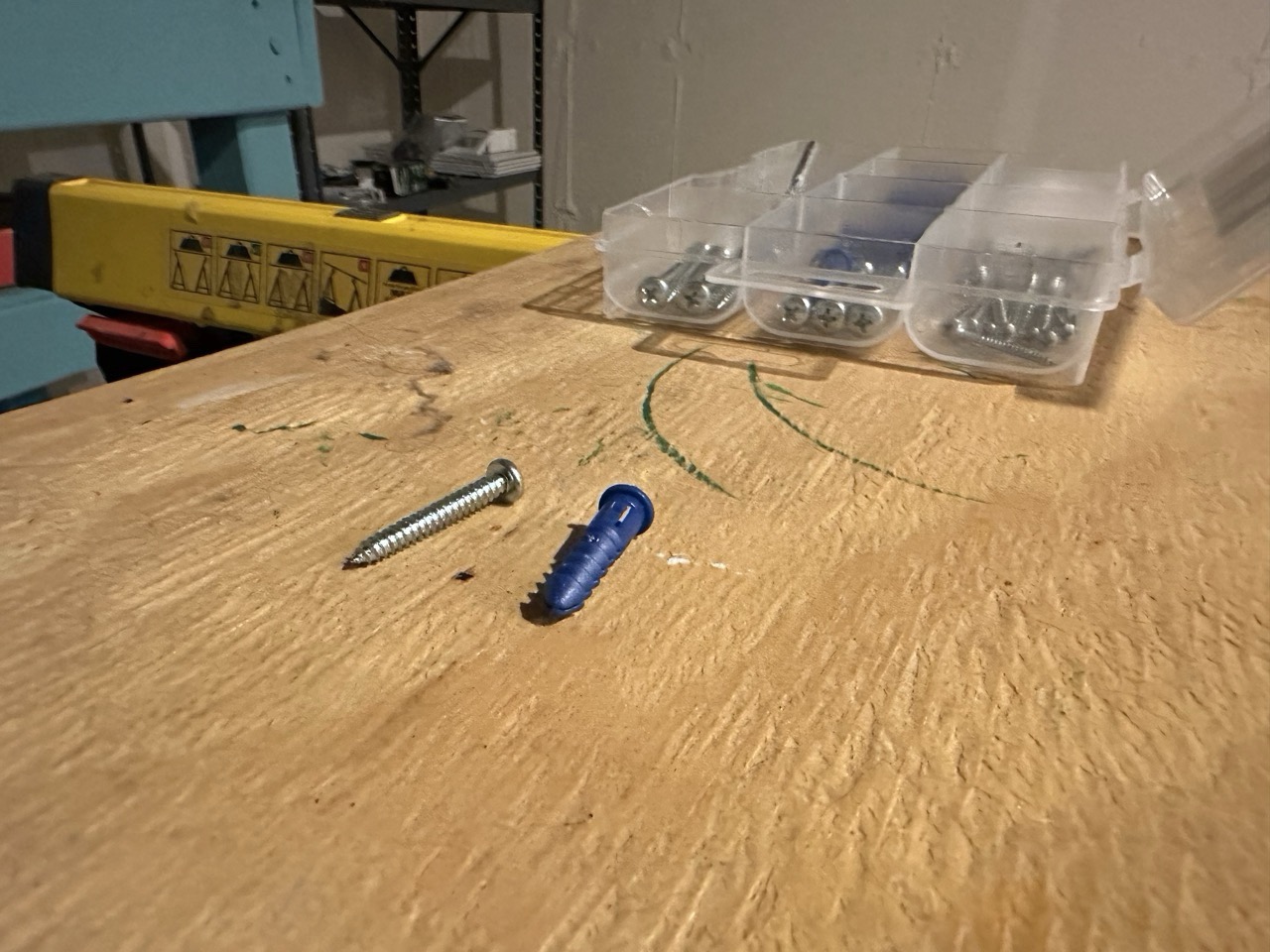 A wall anchor and screw on a board